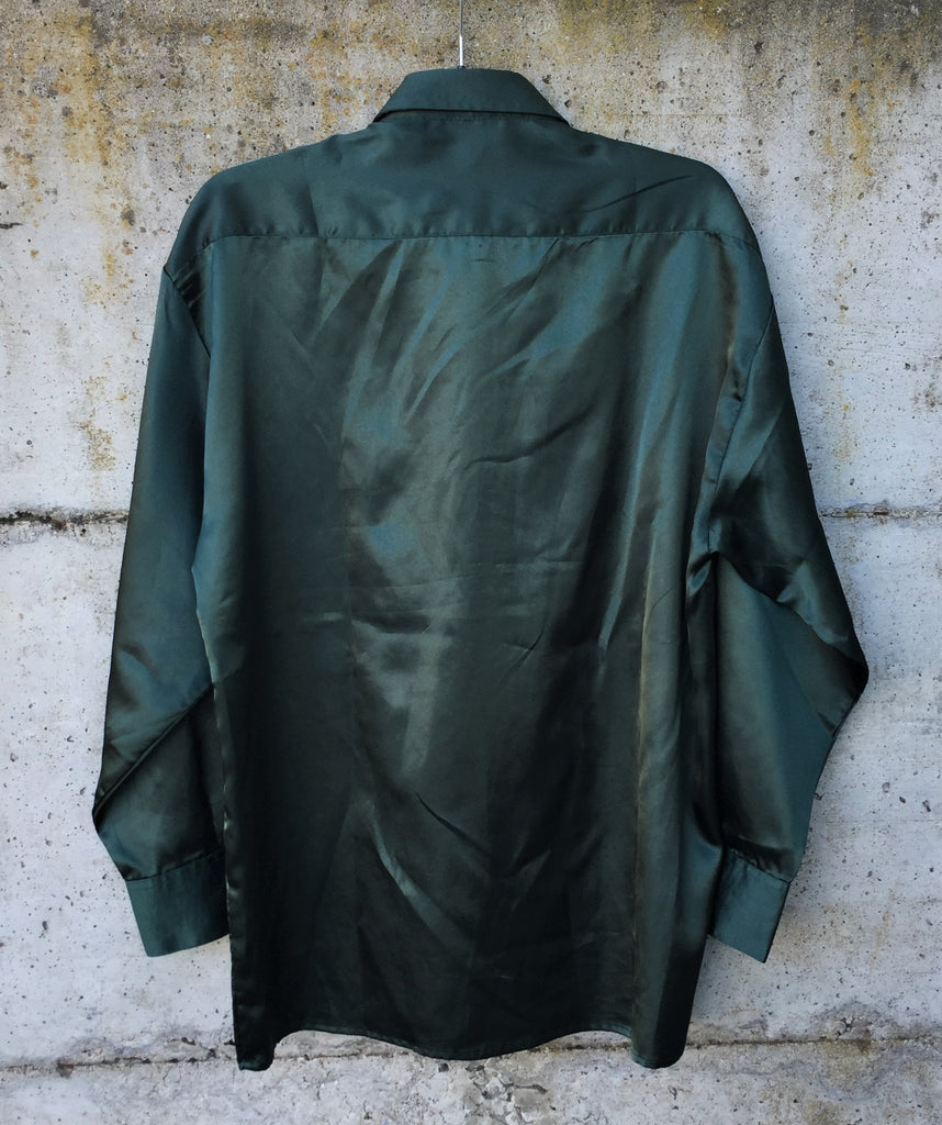 Acheter une chemise satinée "vintage" en Auvergne Rhône-Alpes. Chemise verte sapin satinée, fermeture avec des bouton de la même couleur, une poche plaqué et bouton de manchette. Marque: Balafre Taille: 44 Composition:100% polyester.