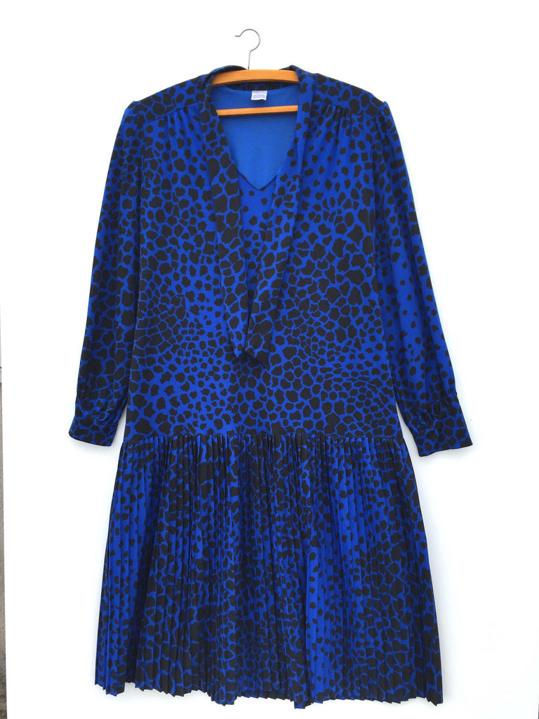 Robe bleue à motifs léopard, mi-longue, plissée. Manches longues.